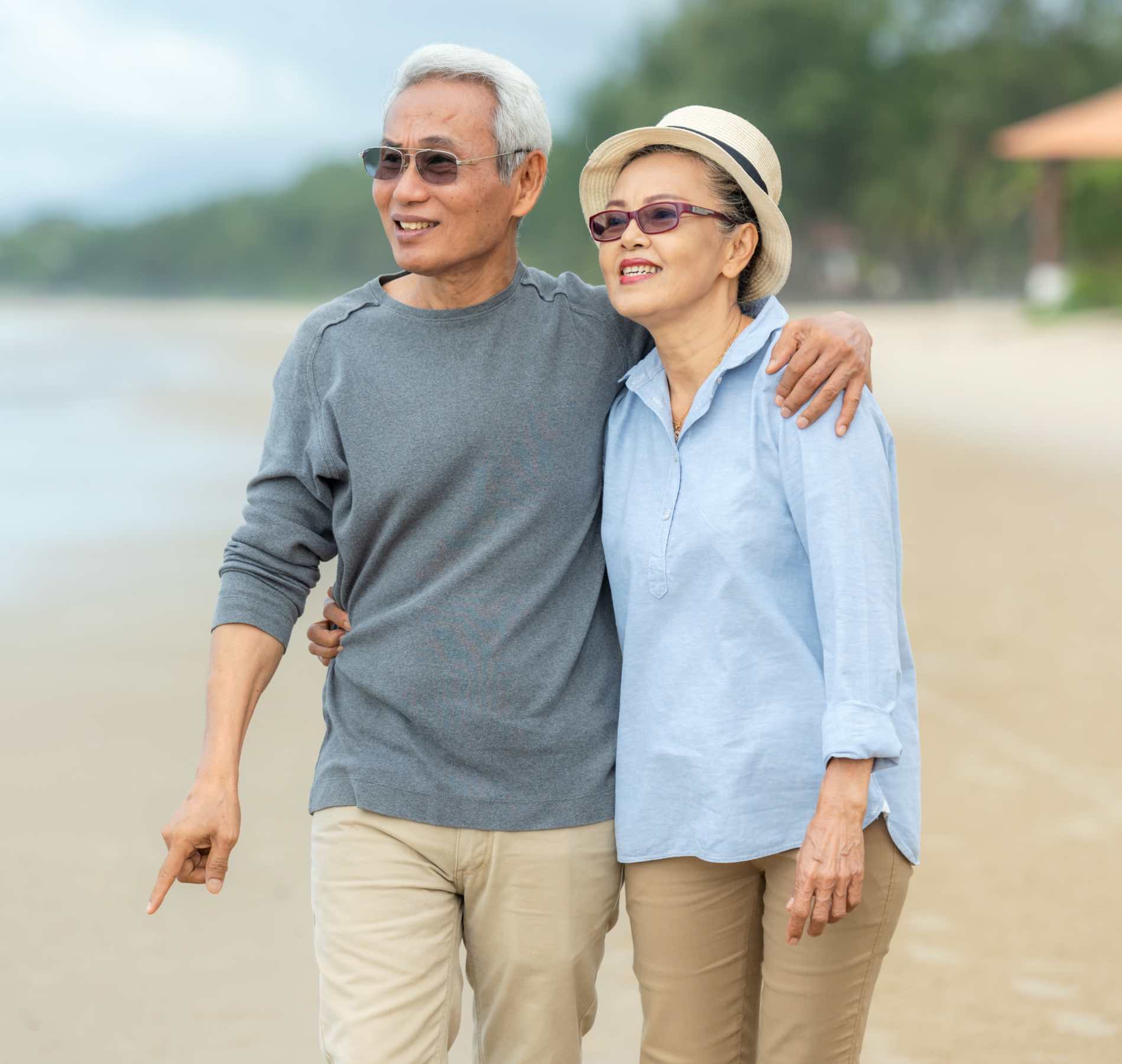 Couple walking on the beach - alternative methods of neck pain treatment with Chronic Care of Richmond could greatly improve your quality of life.